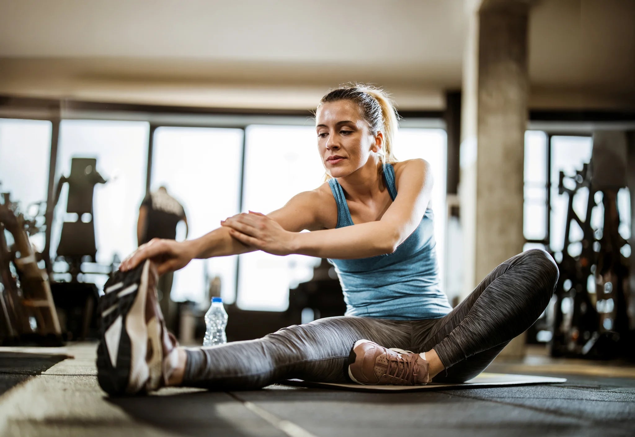 Fitnesstrainerin beim Dehnen