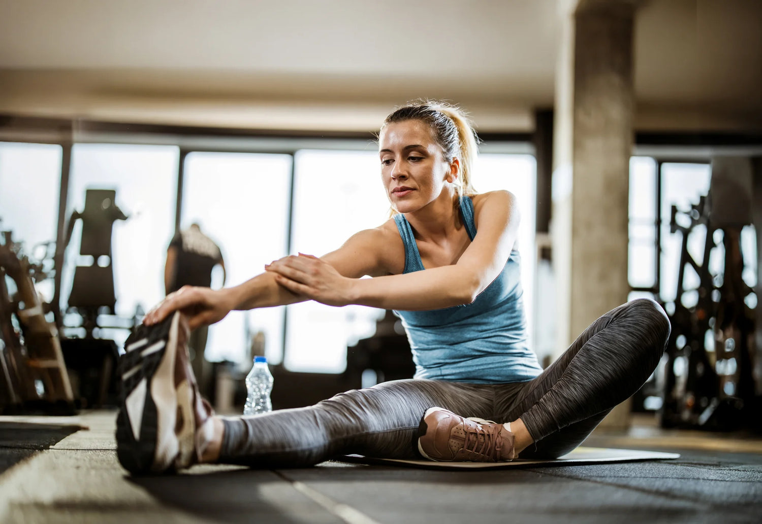 Fitnesstrainerin beim Dehnen